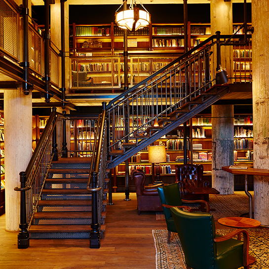 grand staircase in library, connecting two floors of bookshelving in the hotel emma library